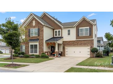 Two-story house with stone accents and a three-car garage at 13929 Tilesford Ln, Huntersville, NC 28078