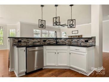 Modern kitchen with white cabinets, stainless steel appliances, and decorative backsplash at 13929 Tilesford Ln, Huntersville, NC 28078