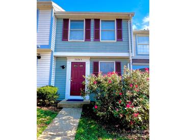 Charming townhome with colorful shutters and a well-maintained front garden with flowering bushes at 7324 Pebblestone Dr # F, Charlotte, NC 28212