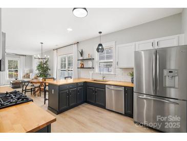Bright open kitchen with stainless steel appliances and butcher block countertops at 8225 Ballymore Ct, Huntersville, NC 28078