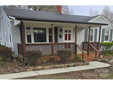 Charming single-story home featuring a covered front porch, gray siding, and well-maintained landscaping at 27 Sw Barbee Rd, Concord, NC 28027