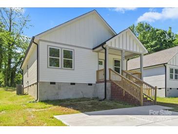 Charming new construction home featuring white siding, brick stairs, and a welcoming covered front porch at 1105 Kenly St, Salisbury, NC 28144