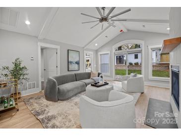 Cozy living room with vaulted ceiling, fireplace, and access to backyard at 1320 Brook Rd, Charlotte, NC 28205