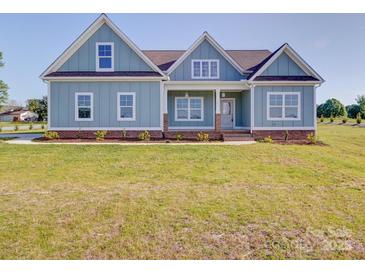 Charming light blue home featuring a well-manicured lawn and inviting front porch at 220 W Lawyers Rd, Monroe, NC 28110