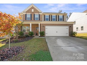 Two-story brick home with a white garage door and landscaping at 221 Tackle Box Dr, Troutman, NC 28166