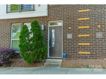 Charming brick townhome with a private front entrance and a well-maintained landscaped garden at 947 Warren Burgess Ln, Charlotte, NC 28205