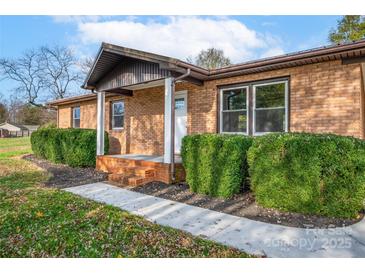 Brick ranch house with landscaped yard and a covered porch at 130 Island Park Ln, Statesville, NC 28625