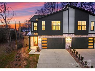 Modern two-story townhome exterior features stone accents and black garage doors at twilight at 2201 Catalina Ave, Charlotte, NC 28206