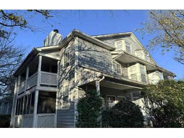 Two-story home featuring a front porch and upper balcony with white wooden railings and gray siding at 6017 Treetop Ct, Charlotte, NC 28212