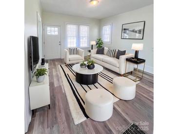 Bright living room featuring hardwood floors, neutral paint, and lots of natural light at 1313 Eastway Dr, Charlotte, NC 28205