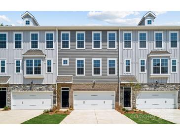 Three-unit townhome building with gray siding, brick accents, and two-car garages at 7112 Brookview Ln, Sherrills Ford, NC 28673