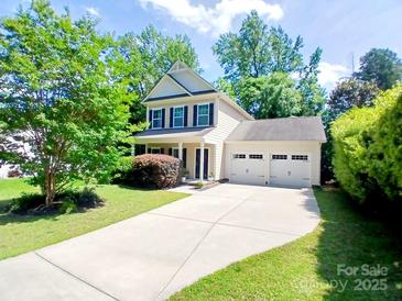 Charming two-story home featuring a two-car garage and a well-manicured lawn with mature trees at 13112 Appolinaire Dr, Davidson, NC 28036