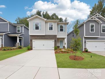 Charming two-story home with a well-manicured lawn, neutral siding, light blue shutters, and a two-car garage at 4019 Bufflehead Dr, Charlotte, NC 28269