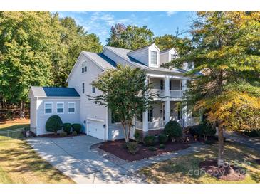 Charming two-story home boasts a welcoming front porch, attached garage, and landscaped front yard at 14027 Grand Traverse Dr, Charlotte, NC 28278