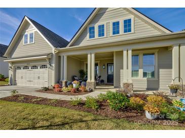 Two-story house with beige siding, a front porch, and landscaping at 14535 Crosswater Ln, Charlotte, NC 28278