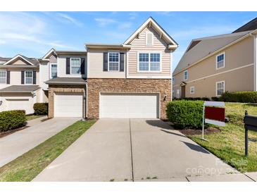 Inviting home featuring a stone facade, a two-car garage, and well-maintained landscaping at 14423 Glendon Hall Ln, Charlotte, NC 28262