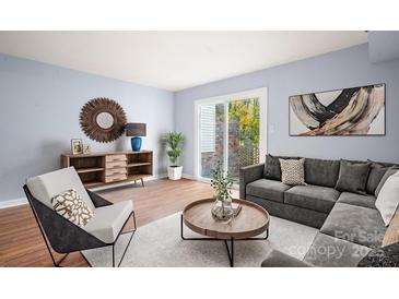 Bright living room with wood floors, comfy seating, and sliding glass door to patio at 2705 North Center St # 74, Hickory, NC 28601