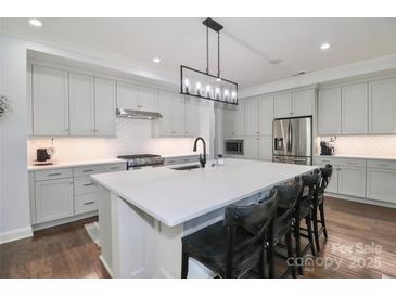 Bright kitchen features stainless steel appliances, white cabinets, and a large center island with counter seating at 12023 Huntson Reserve Rd, Huntersville, NC 28078