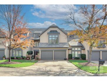 Two-story townhome with gray exterior, two-car garage, and landscaping at 5635 Ballinard Ln, Charlotte, NC 28277