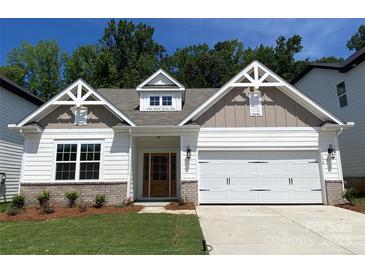 Charming home showcasing a manicured lawn, brick accents, and a well-lit two-car garage at 9130 Dulwich Dr # Ken0079, Charlotte, NC 28215