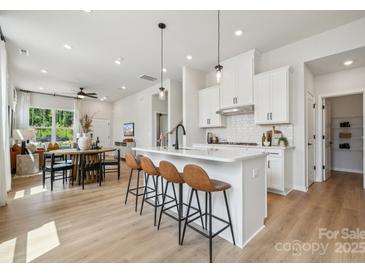 Open concept kitchen with white cabinets, island, and stainless steel appliances at 1194 Lost Cove Rd, Indian Land, SC 29707