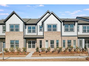 Two-story townhome with brick and siding exterior, landscaping, and a walkway at 1198 Lost Cove Rd, Indian Land, SC 29707