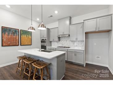 Modern kitchen with island, stainless steel appliances, and gray cabinets at 1198 Lost Cove Rd, Indian Land, SC 29707