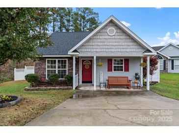 Charming single-story home with a stone and vinyl exterior, a cozy front porch, and a red front door at 307 Tara Elizabeth Pl # 22, Kannapolis, NC 28083