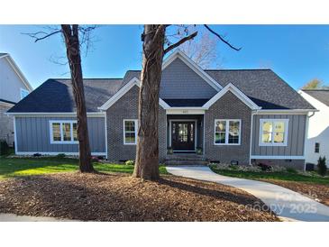 Gray brick and board and batten home with landscaped yard at 405 19Th Avenue Nw Cir, Hickory, NC 28601