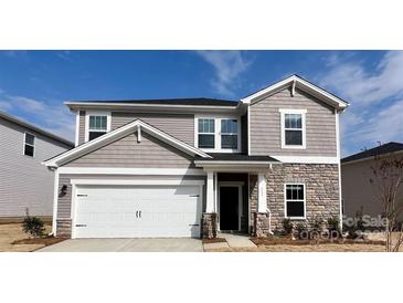 Charming two-story home featuring a stone accent, a two-car garage, and manicured landscaping at 111 Sentinel Ct, Mooresville, NC 28115