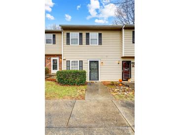 Tan siding townhouse exterior with landscaping and walkway at 6102 Heath Ridge Ct # G, Charlotte, NC 28210