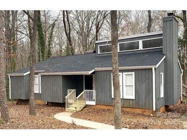 Charming home featuring a gray exterior, complemented by white trim and a cozy front porch with wooden railing at 958 Sherwood Cir, Lancaster, SC 29720