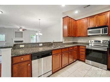 Well-lit kitchen featuring granite countertops, stainless steel appliances and wood cabinetry at 310 Rose Garden Ct, Rock Hill, SC 29732