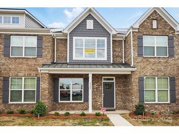 Charming brick townhome featuring gray shutters, craftsman columns, and professionally landscaped yard at 5527 Stafford Rd # 34, Charlotte, NC 28215