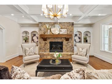 Inviting living room features a stone fireplace flanked by built-in bookshelves and stylish decor at 1716 Funny Cide Dr, Waxhaw, NC 28173