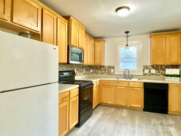 Galley kitchen with wood cabinets and modern appliances at 606 Carver St, Kannapolis, NC 28083
