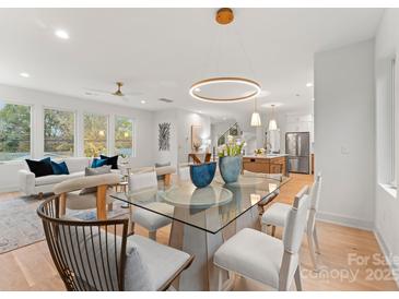 Bright dining room with glass table and modern chairs, open to living area at 2911 Hilliard Dr, Charlotte, NC 28205