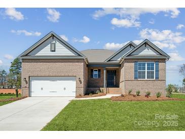 Charming brick home features a manicured lawn, attached garage, and stylish architectural details at 127 Jentri Way, Mooresville, NC 28115