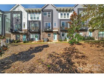 Modern townhomes with gray siding, balconies, and beautifully landscaped front yard at 582 West End Dr, Charlotte, NC 28208