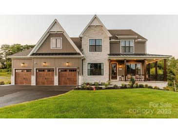 Two-story house with stone and brown siding, three-car garage, and landscaped yard at Lot 51 Watercourse Way # Nottingham, Belmont, NC 28012