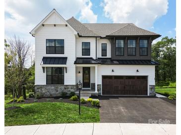 Beautiful two-story home featuring white siding, a stone accent wall, black trim, and a spacious two-car garage at Lot 51 Watercourse Way # Covington, Belmont, NC 28012