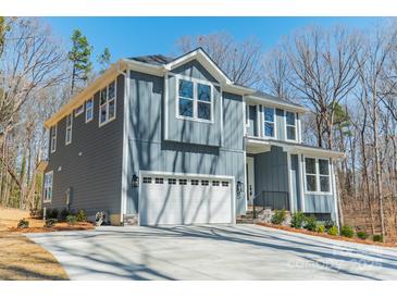 Two-story home with a white garage door, gray siding, and white trim, with well-manicured landscaping at 149 Pinewood St, Troutman, NC 28166