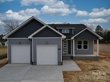 Newly constructed home with gray siding, two-car garage, and a landscaped front yard at 2335 Emanuel Church Rd, Rockwell, NC 28138