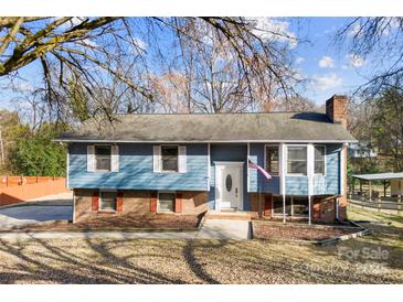 Charming blue home featuring brick accents and a well-manicured front yard at 5034 Clearwater Lake Rd, Mount Holly, NC 28120