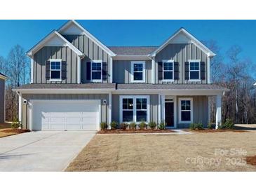 Charming two-story home featuring a symmetrical facade, a well-manicured lawn, and a two car garage at 251 Winford Rd, Troutman, NC 28116