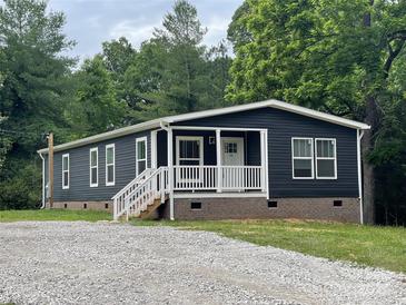 Charming one-story home with navy blue siding, white trim, and a gravel driveway surrounded by lush trees at 1100 Turkey Creek Ridge Rd, York, SC 29745