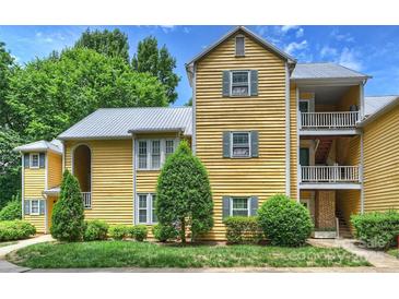 Charming yellow condo with multiple balconies and lush landscaping at 3302 Selwyn Farms Ln, Charlotte, NC 28209