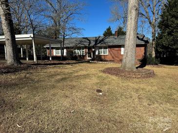 Brick ranch house with carport and mature trees at 323 Breslin St, Wadesboro, NC 28170