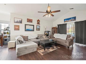 Inviting living room with vaulted ceilings, wood floors, and neutral decor offers an open and airy space at 8931 Meadow Vista Rd, Charlotte, NC 28213