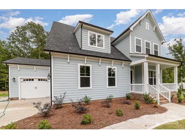 Charming two-story home with a light blue exterior, a white garage door, and a well-manicured front yard at 562 Shepherd Ln, Clover, SC 29710